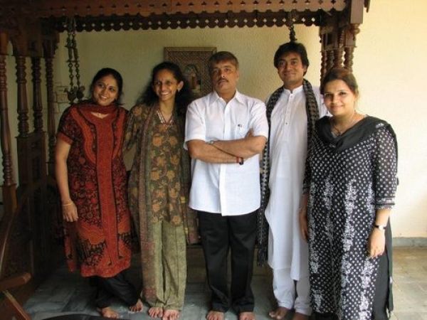 Group of five people standing together indoors, dressed in traditional and semi-formal Indian clothing.